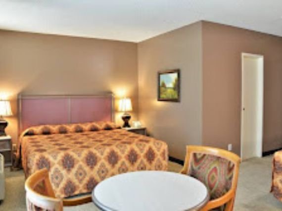 interior view of a Hotel PG room showcasing two beds and a table, ideal for travelers seeking a cozy stay.