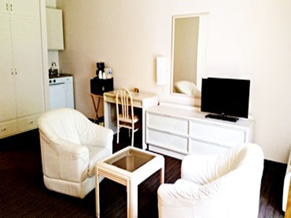 Hotel PG room with two beds and a television, providing a welcoming atmosphere for travelers and guests.